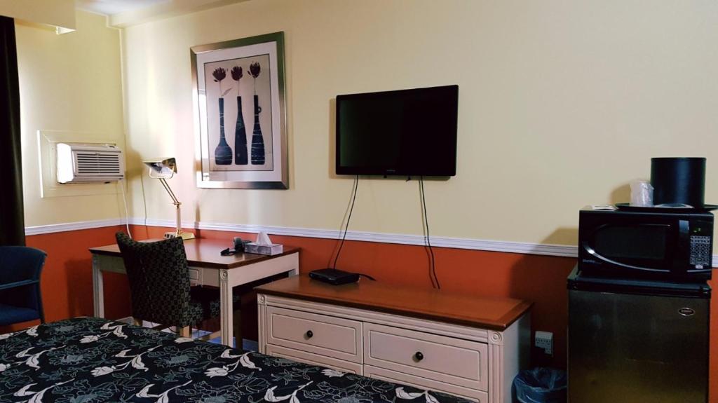汉密尔顿Budget inn 2000的酒店客房设有一张桌子和一台墙上的电视。