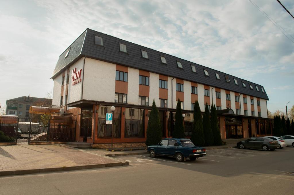 KlintsyUyut Centralnaya Hotel的停车场内有停车位的建筑物