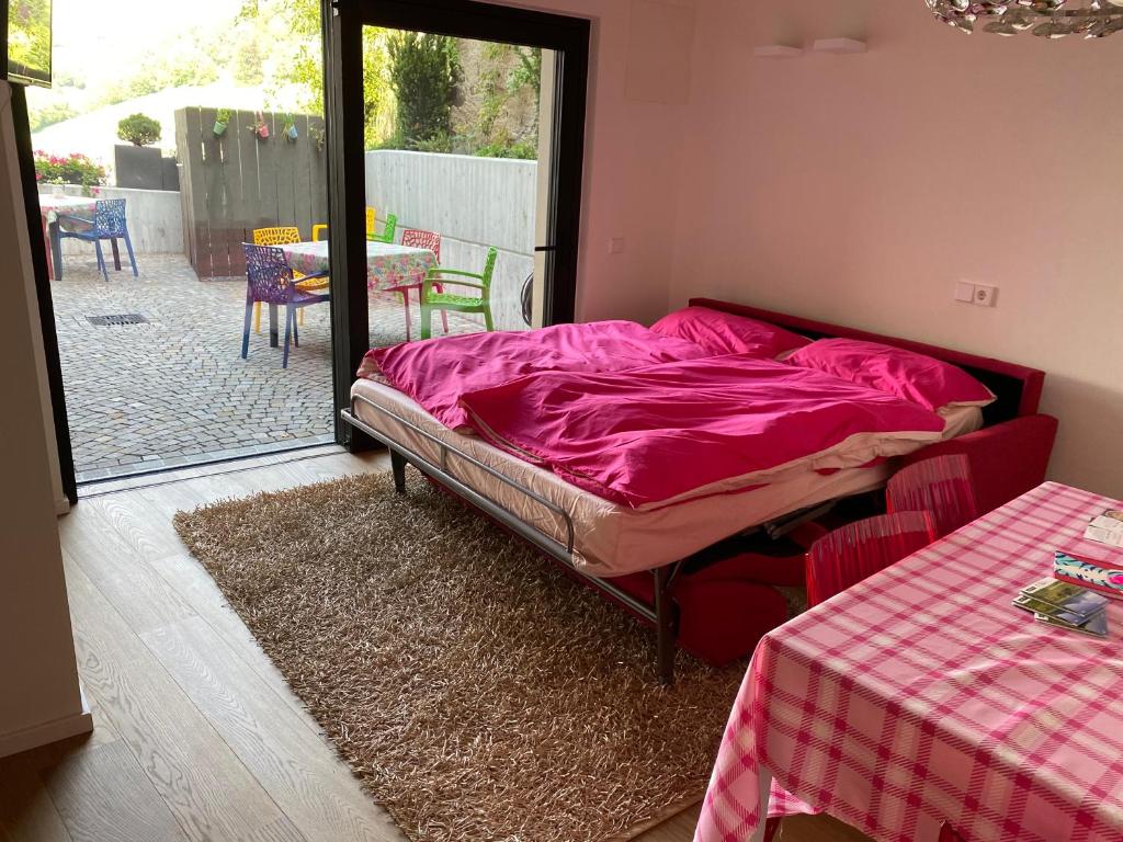 菲耶Casa Sciliar centro paese PINK的一间卧室配有一张床铺,床上铺有粉色毯子