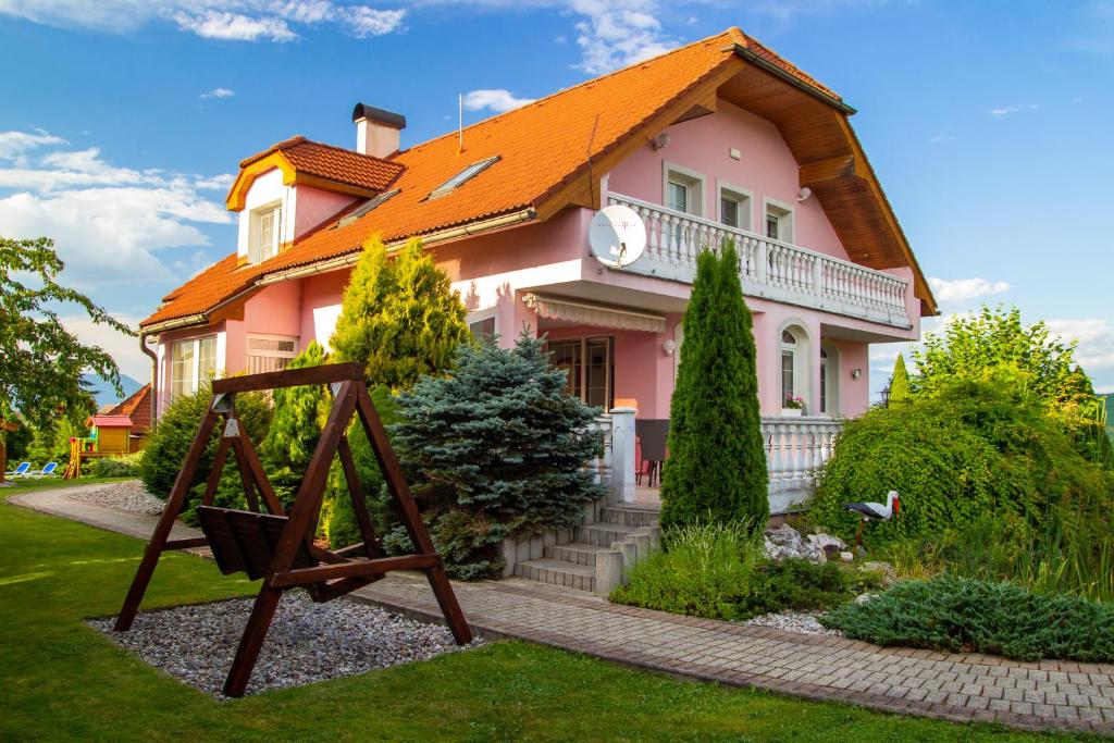利普托斯基米库拉斯WOW Liptov Holiday House的橙色屋顶的粉红色房子