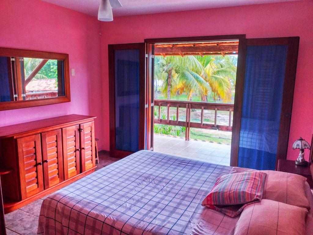 伊列乌斯Feriasmares的卧室设有粉红色的墙壁、一张床和窗户