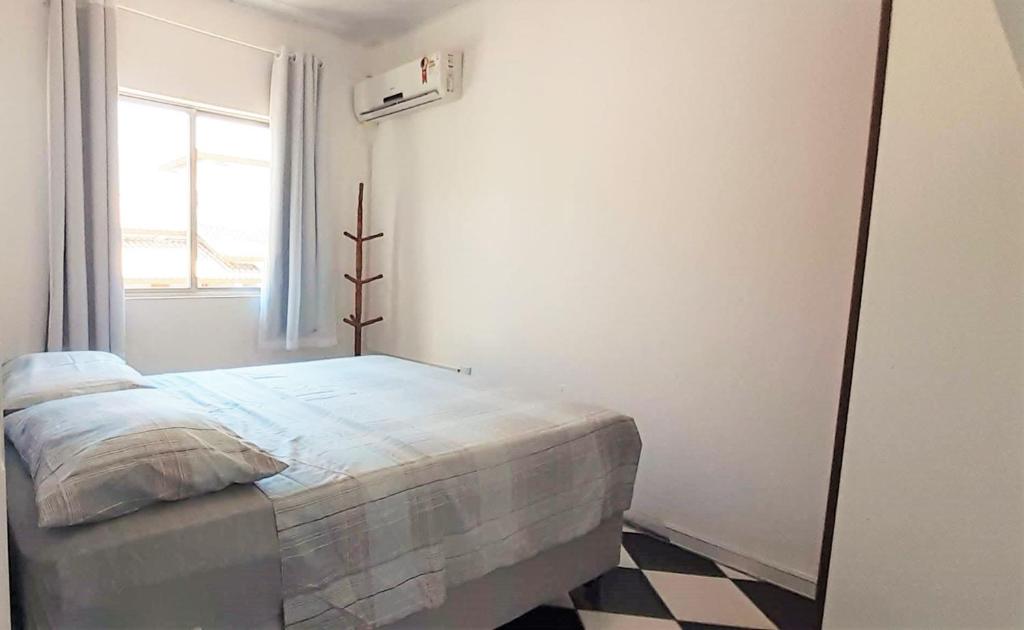 邦比尼亚斯Residencial di Raffaele em Bombinhas的白色的卧室设有床和窗户