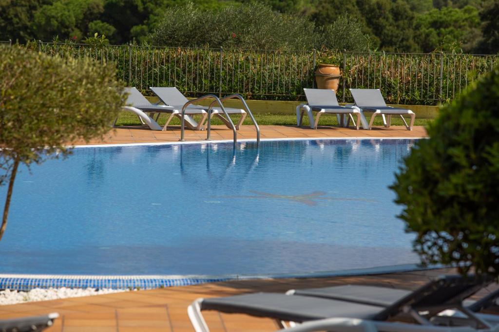圣塔克里斯蒂纳阿鲁RVHotels Golf Costa Brava的游泳池旁的一排躺椅