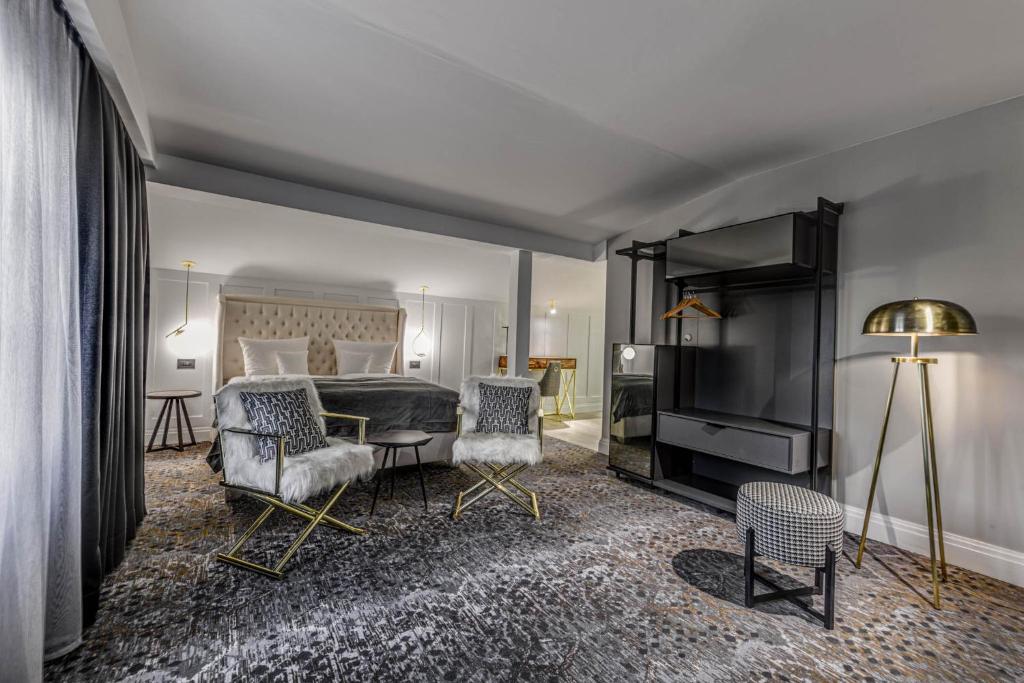 蒂米什瓦拉HOTEL BOUTIQUE DONNA ANNA的酒店客房,配有一张床和两把椅子