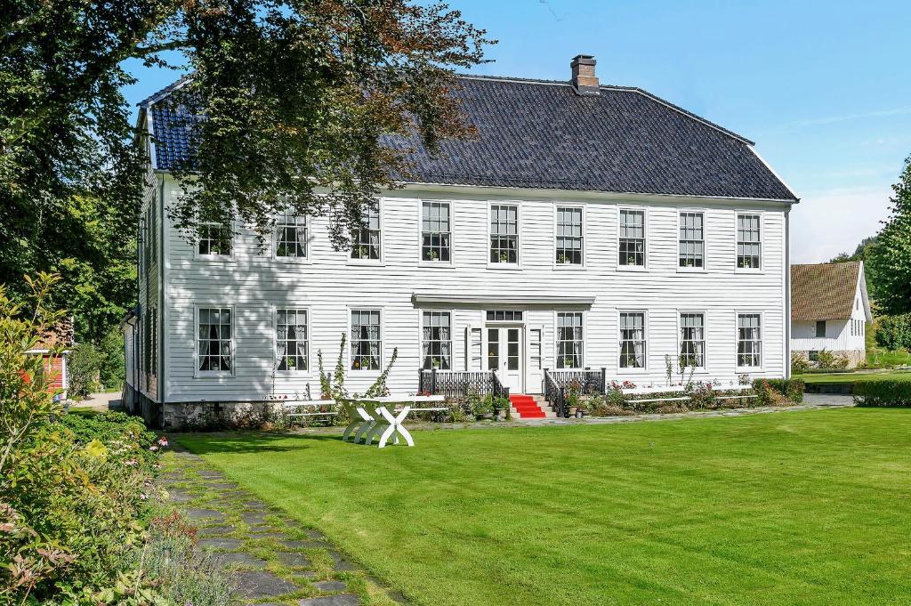 克里斯蒂安桑Boen Gård的一座大型白色房子,设有大型绿色庭院