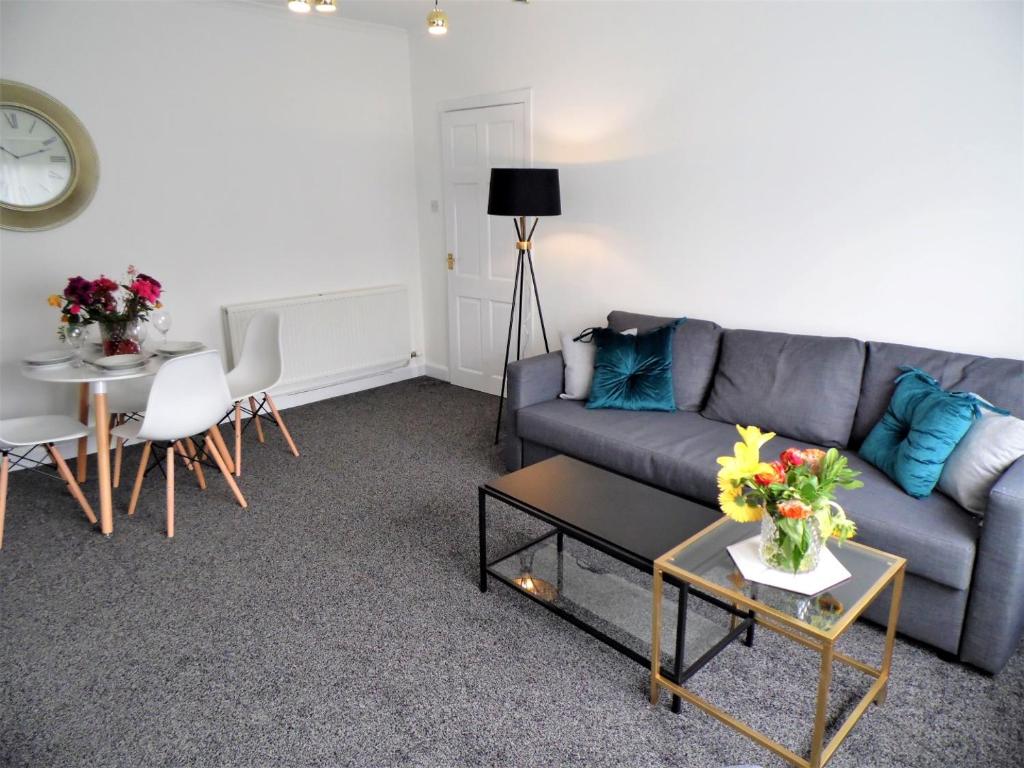 格拉斯哥Penilee Upper Apartment的客厅配有沙发和桌子