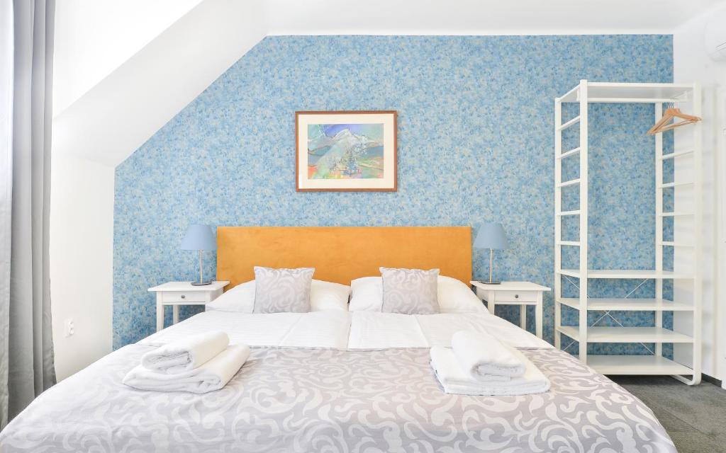 布拉迪斯拉发BlueBell Hotel的一间卧室设有一张床和蓝色的墙壁