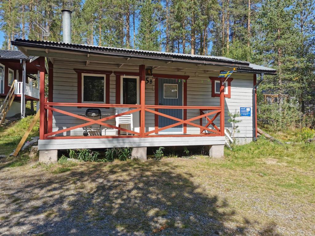 伊德勒Fjällstuga 5B i Foskros m kamin的小屋设有木门廊,位于树林中