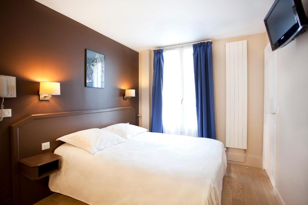 巴黎纳道酒店的卧室配有白色的床和窗户。