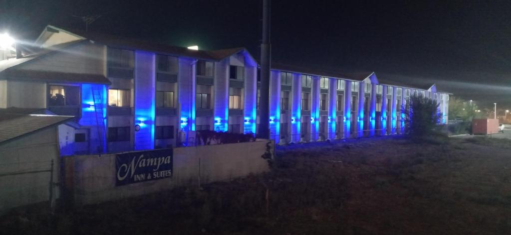 楠帕南帕套房酒店的一座晚上有蓝色灯光的建筑