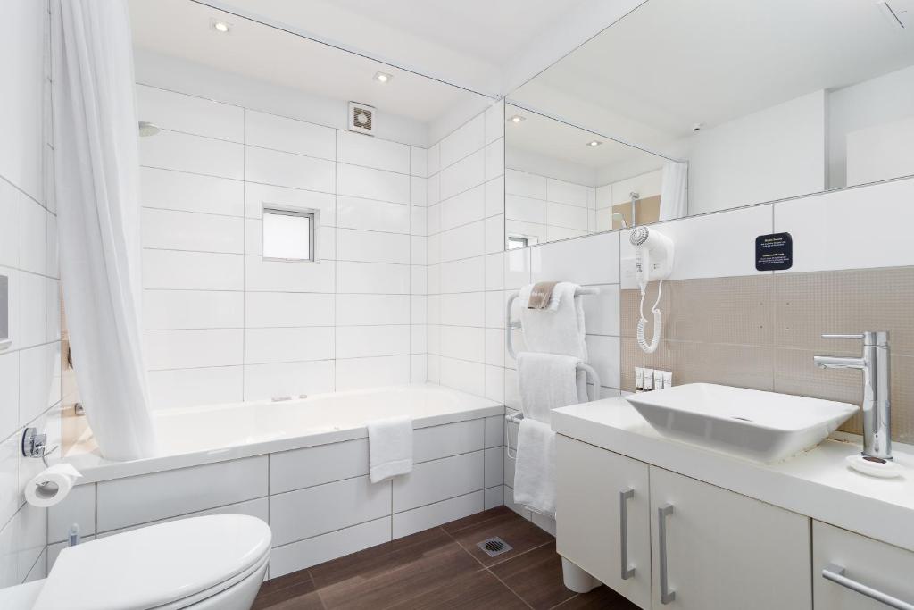 纳尔逊Century Park的白色的浴室设有卫生间和水槽。