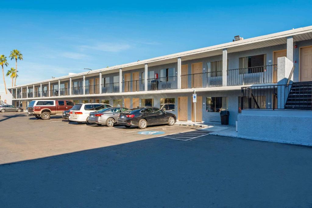 凤凰城Rodeway Inn Phoenix North I-17的停车场内有车辆的建筑物