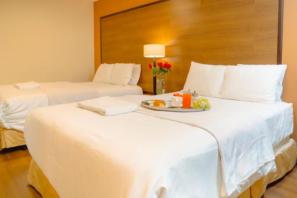 昆卡Hotel La Farola的一张带一盘食物的酒店客房内的两张床