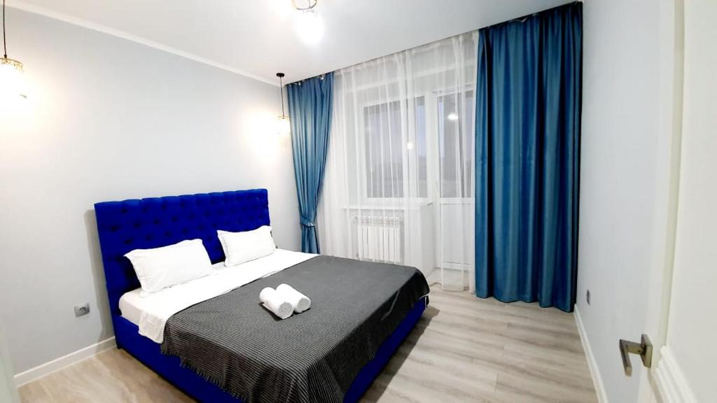科克舍套1 ком квартира Аблайхана 1的一间卧室配有蓝色的床和蓝色窗帘