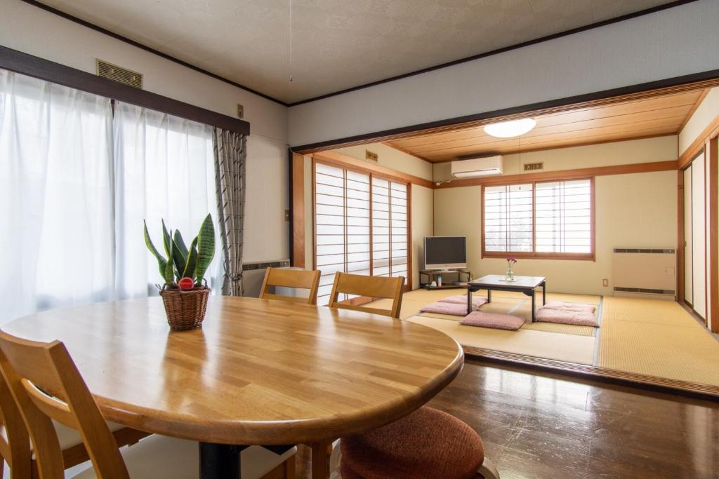 富士吉田市Guest house Fujinoyado Akebono - Vacation STAY 92428的一间带木桌的用餐室和一间客厅。