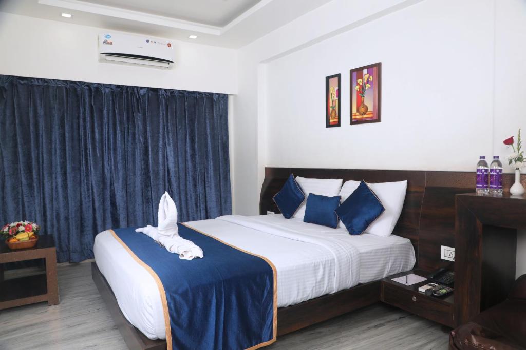 罗纳瓦拉Hotel Planet Four的一间卧室配有一张带蓝白色枕头的大床