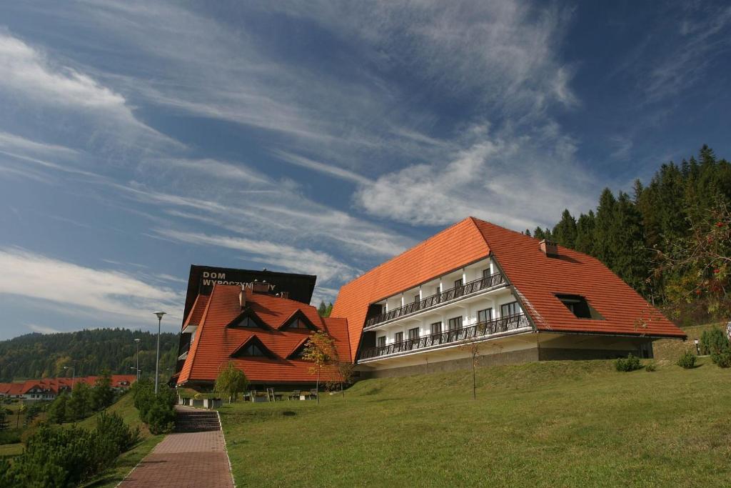 涅兹卡城堡Dom Wypoczynkowy Pod Taborem的一座在田野上拥有橙色屋顶的建筑