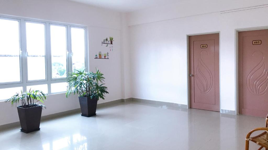 瓜拉丁加奴Alexis KT Roomstay的一间有两盆植物的房间和一扇粉红色的门
