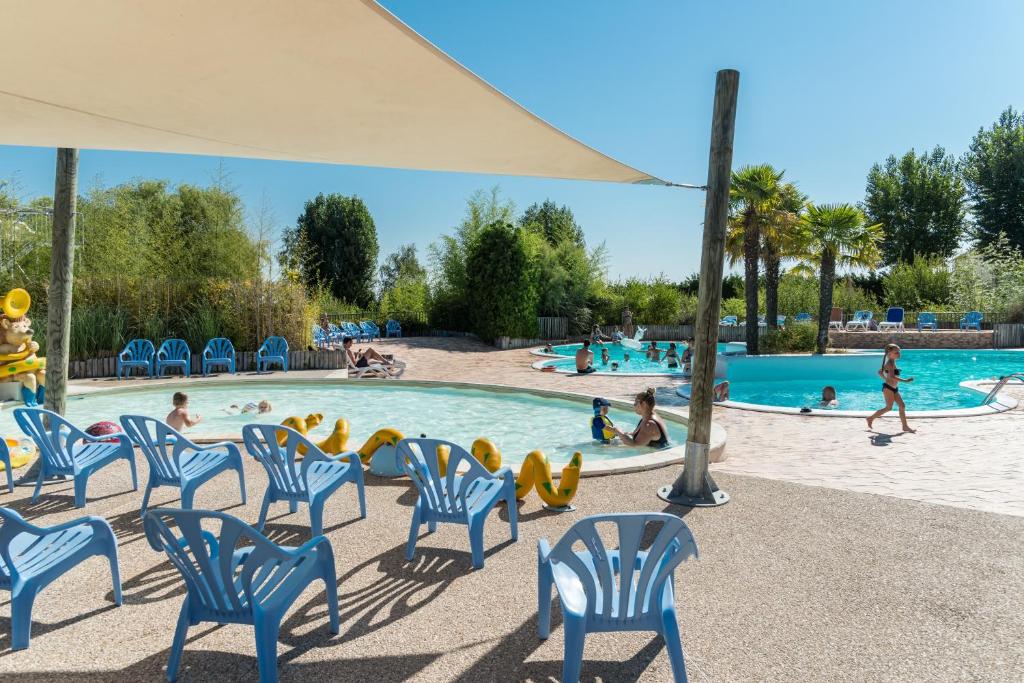 Poilly-lez-GienMobil Home XXL2 4 chambres - Camping Les Bois du Bardelet的游泳池设有蓝色椅子,里面有人