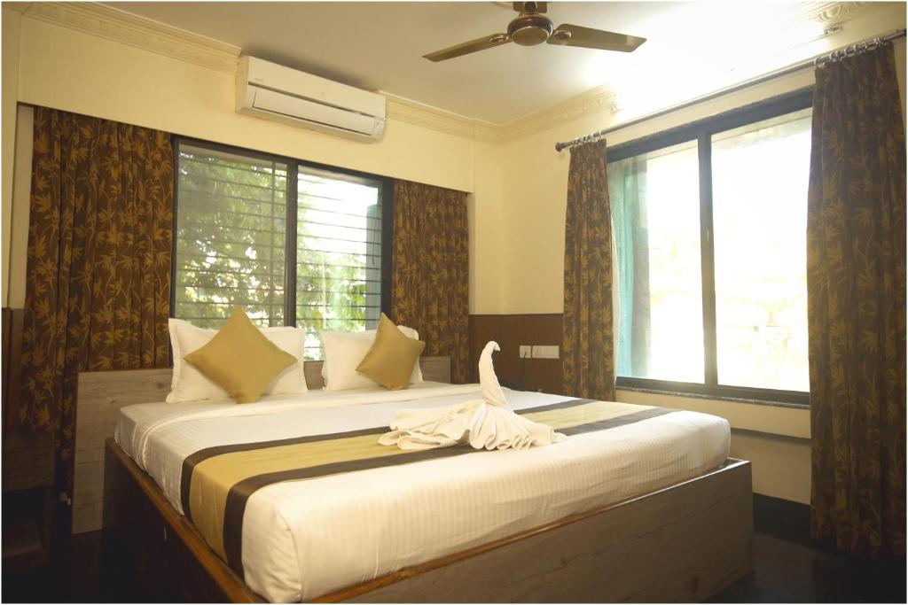 西里古里Apples Balaji Inn的一间卧室配有一张床,床上有毛巾