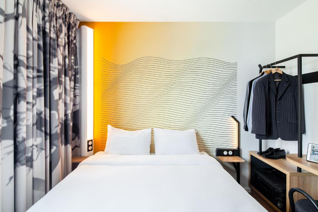 泰昂维B&B HOTEL Thionville Centre Gare的一间卧室设有一张床和黄色的墙壁