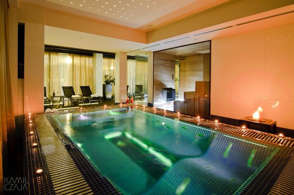 弗罗茨瓦夫Platinum Palace Boutique Hotel & SPA的游泳池位于酒店客房中间