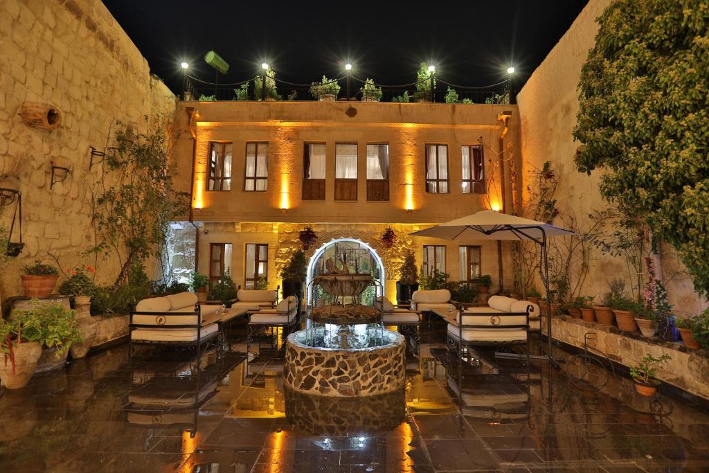 于尔居普Aja Cappadocia Cave Hotel的建筑前带喷泉的庭院