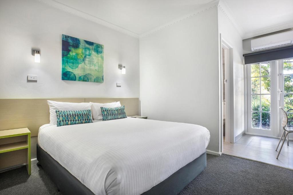 墨尔本Nightcap at Skyways Hotel的卧室设有一张白色大床和一扇窗户。