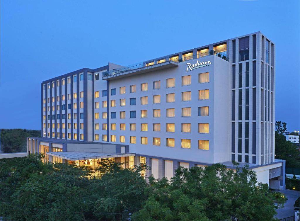 阿格拉Radisson Hotel Agra的黄昏时酒店大楼的 ⁇ 染
