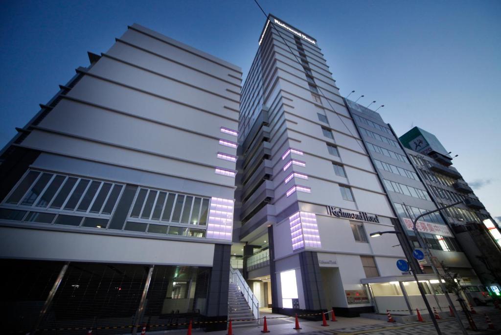 福山福山站前里士满酒店的一座高大的建筑,上面有紫色的灯