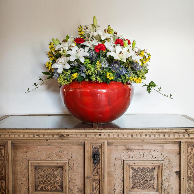 锡尔斯玛丽亚普利瓦塔酒店的橱柜顶上一个红色花瓶