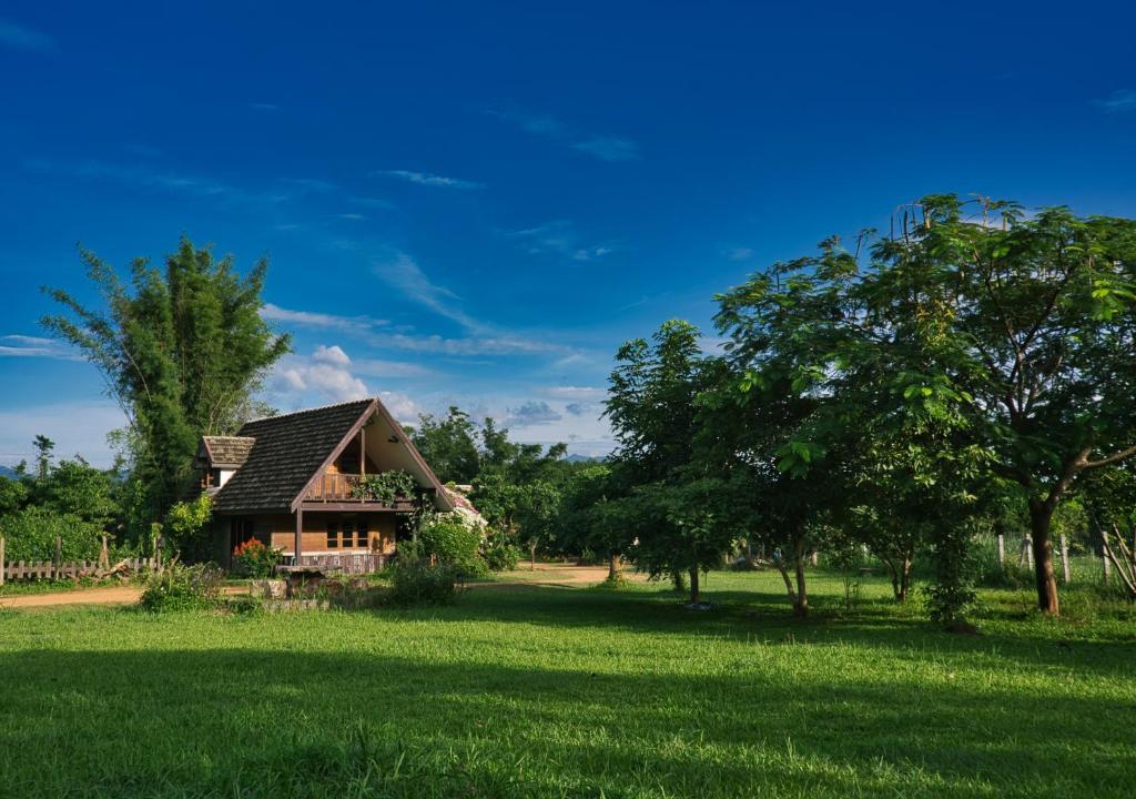 清道Cozycomo Chiang Dao - Wiang Mek的树木林立的田野中的房子