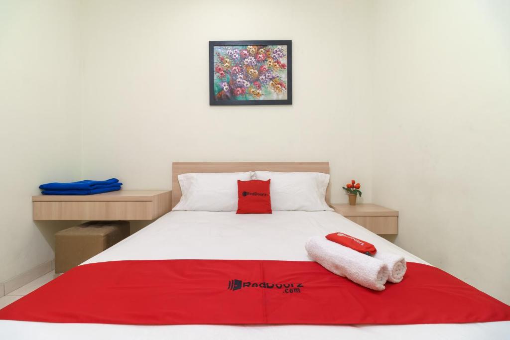 德波RedDoorz Syariah @ Cinere Depok的一间卧室配有一张床,上面有两条毛巾