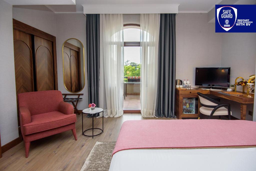第比利斯第比利斯宫殿酒店的一间卧室配有一张床、一把椅子和一张书桌