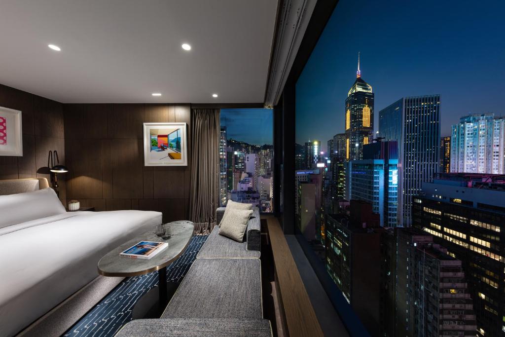 香港The Hari Hong Kong的酒店客房享有城市美景,配有一张床。