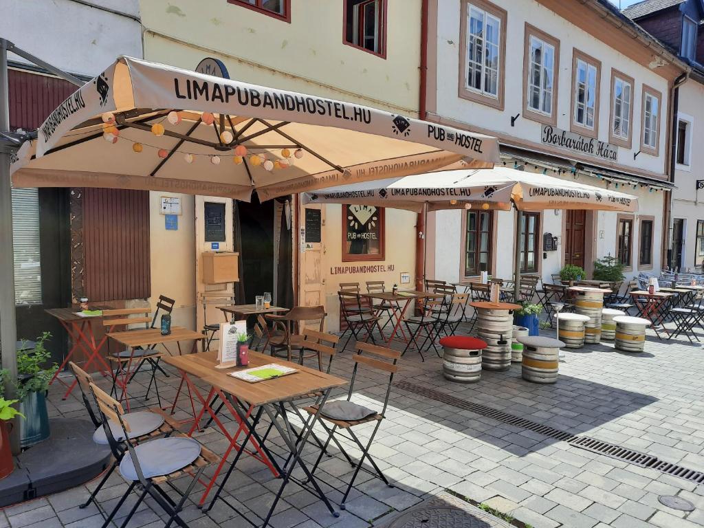 杰尔Borbarátok Háza的室外餐厅设有桌椅和遮阳伞。