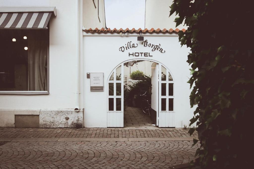 维斯比博根别墅酒店的白色的建筑,有酒店的入口