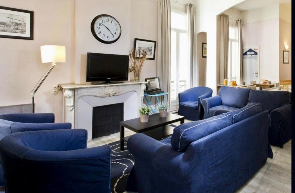 马赛HOTEL SYLVABELLE的客厅配有蓝色椅子和壁炉