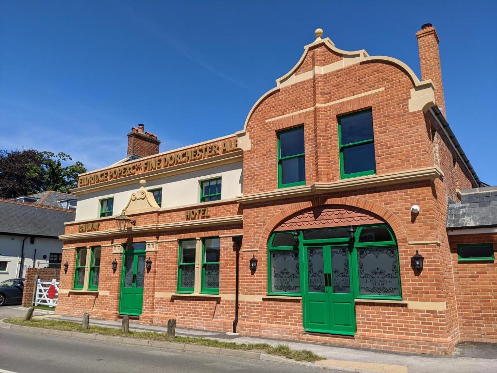 福丁布里奇Railway Hotel的街道上带绿门的旧砖砌建筑