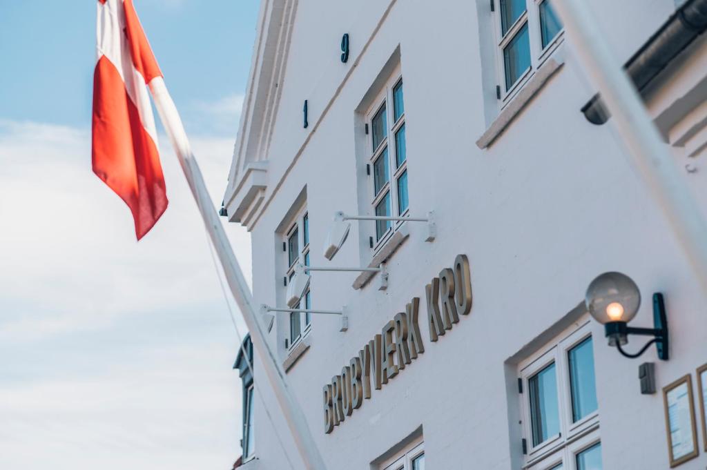Brobyværk波罗比威尔克库洛酒店的一座有旗帜和标志的建筑