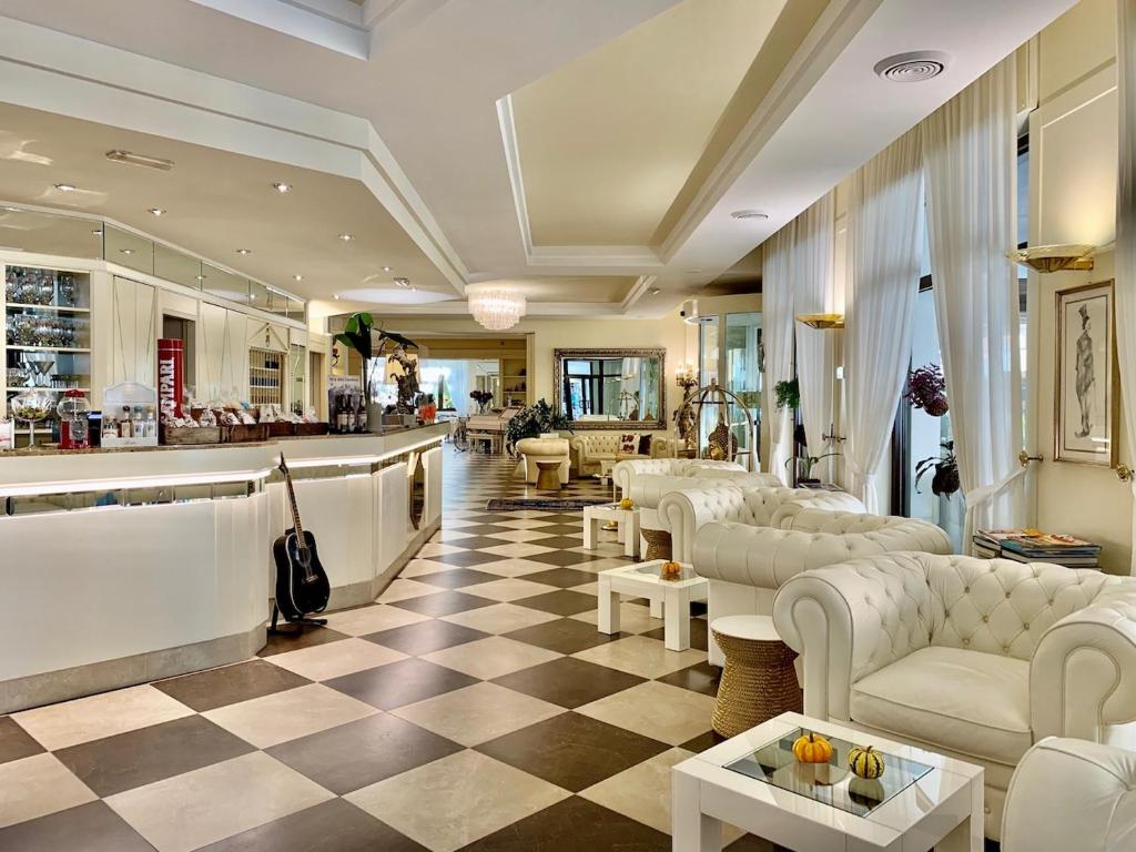 波里奥特米Hotel Brescia & Apartments的大堂设有白色的沙发和 ⁇ 格地板