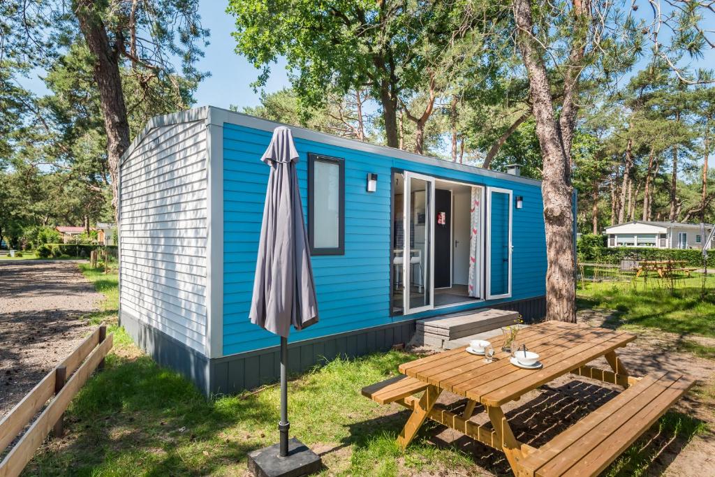 比尔特霍芬Chalet O'hara的蓝色的小房子,配有野餐桌和雨伞