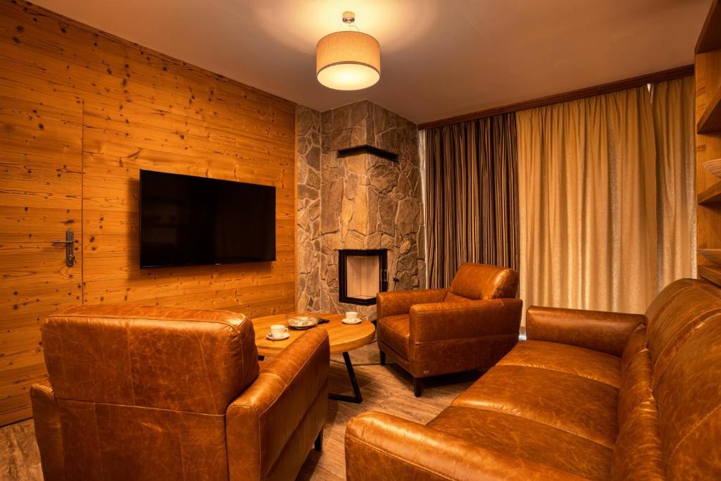 迪马诺卡多林纳DaSus Lux&Wellness Apartments Sosana的客厅配有皮革家具和电视