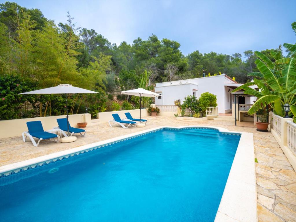 圣卡洛斯托尼马里别墅的一个带蓝色椅子和遮阳伞的游泳池