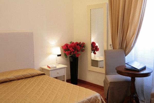 佛罗伦萨壮丽梅塞雷住宿加早餐旅馆的一间卧室,配有一张床和一束红色花