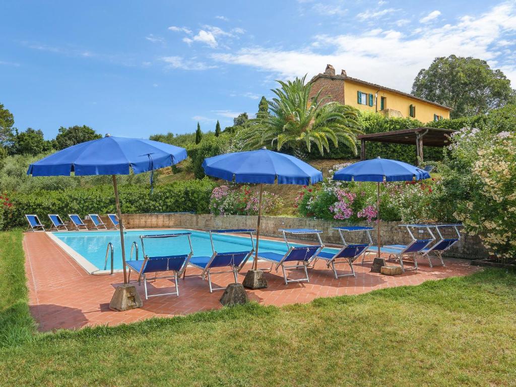 帕拉伊阿Holiday Home Fienile - PAA132 by Interhome的游泳池旁设有椅子和蓝色遮阳伞