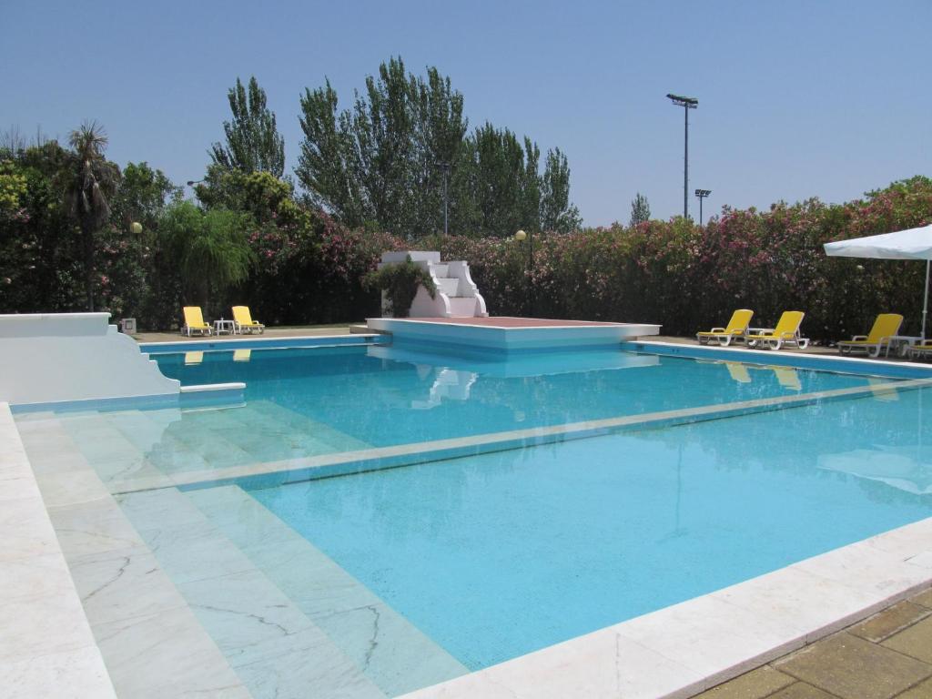 埃尔瓦斯圣卢西亚艾瓦斯酒店的游泳池设有蓝色的海水和黄色的椅子