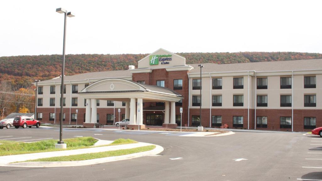 拉瓦莱Holiday Inn Express & Suites Cumberland - La Vale, an IHG Hotel的前面有停车位的大楼