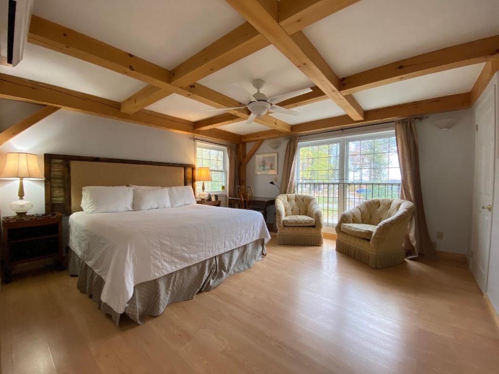 布莱顿木制度假山林小屋的一间卧室配有一张大床和两把椅子