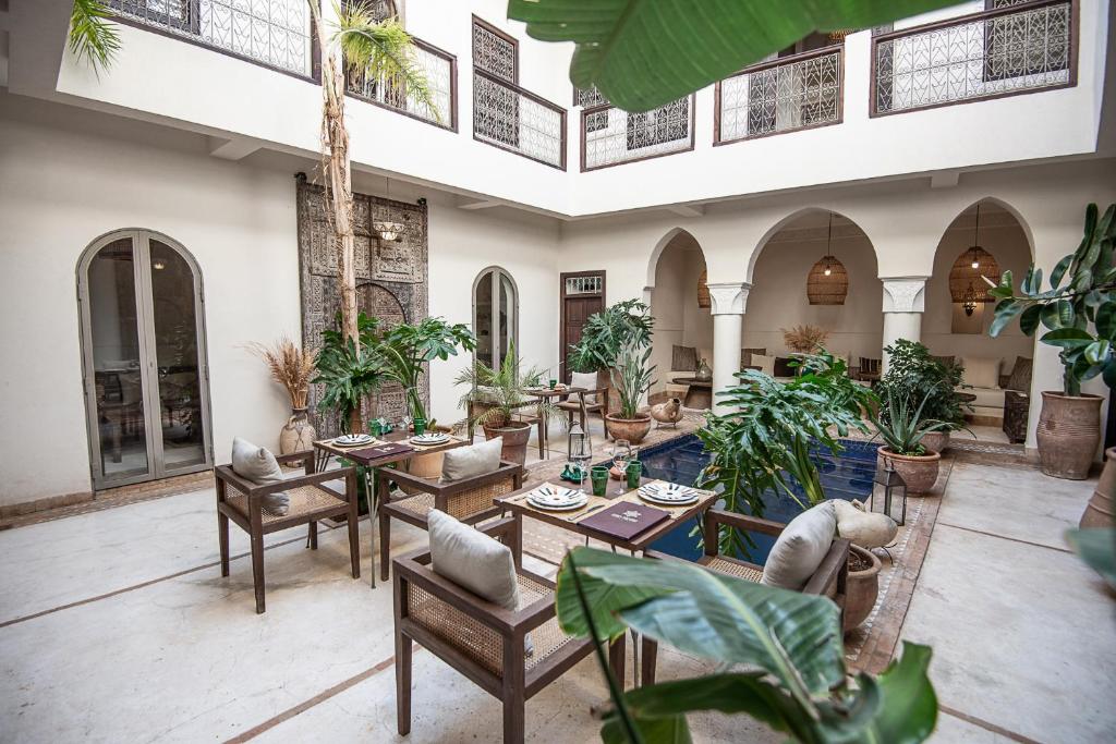 马拉喀什法尔汉庭院旅馆的室内庭院设有桌椅和植物